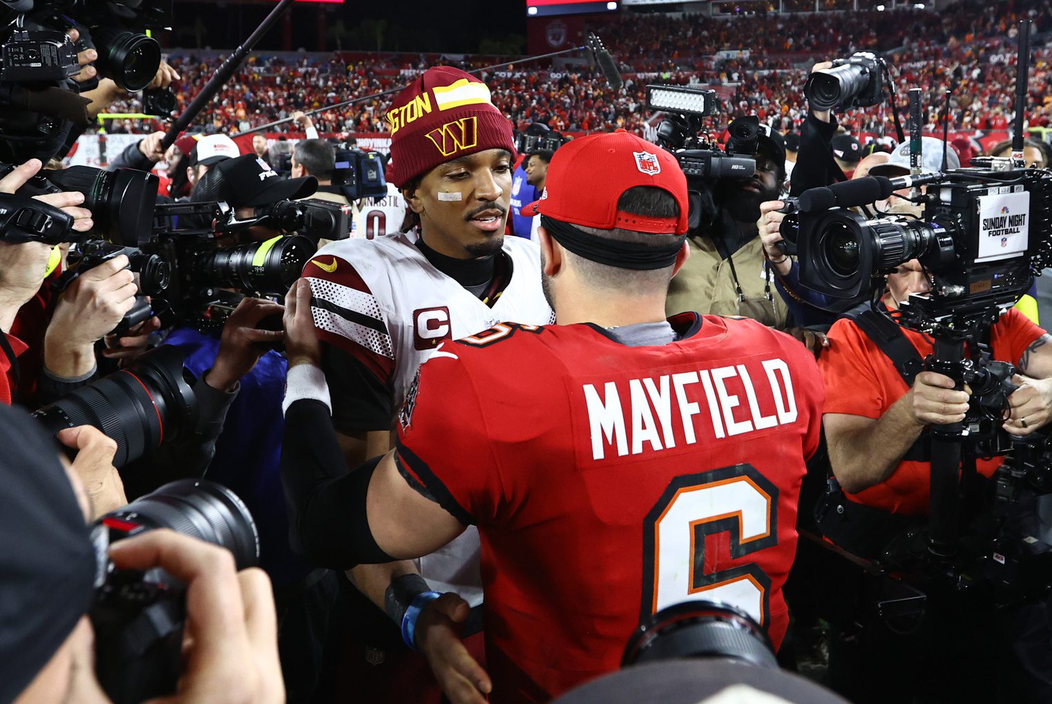 Jan 12, 2025; Tampa, Florida, USA; Washington Commanders quarterback Jayden Daniels (5) greets Tampa Bay Buccaneers quarterback Baker Mayfield (6) after winning a NFC wild card playoff at Raymond James Stadium. Mandatory Credit: Kim Klement Neitzel-Imagn Images Lions