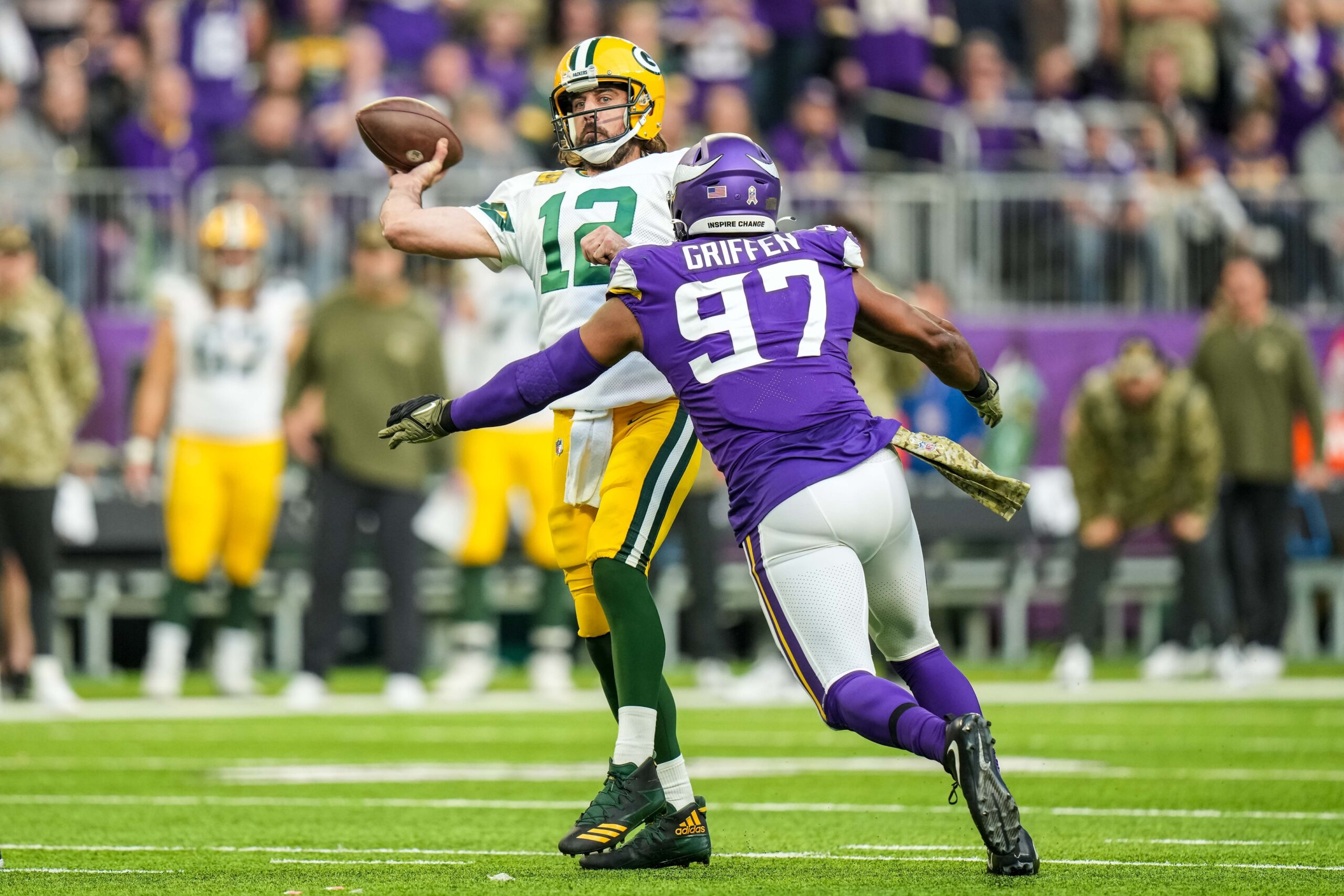 Nov 21, 2021; Minneapolis, Minnesota, USA; Green Bay Packers quarterback Aaron Rodgers (12) throws a touchdown pass in front of Minnesota Vikings defensive end Everson Griffen (97) during the fourth quarter at U.S. Bank Stadium. Mandatory Credit: Brace Hemmelgarn-Imagn Images