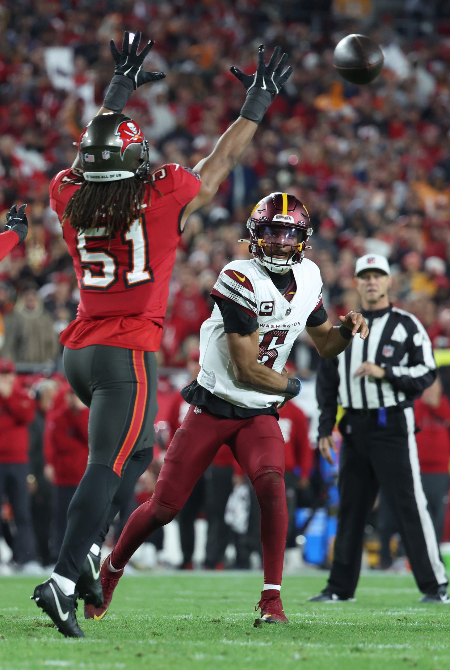 Jan 12, 2025; Tampa, Florida, USA; Washington Commanders quarterback Jayden Daniels (5) throws against Tampa Bay Buccaneers linebacker J.J. Russell (51) during the fourth quarter of a NFC wild card playoff at Raymond James Stadium. Mandatory Credit: Kim Klement Neitzel-Imagn Images NFL