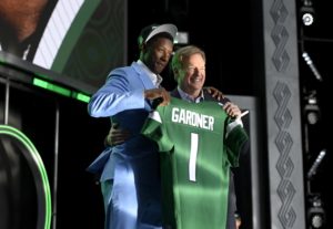 Ahmad Gardner standing with Roger Goodell at draft holding his Jets jersey after being picked 