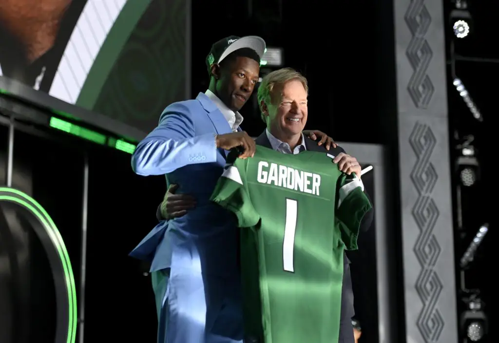 The Jets first round pick Ahmad Gardner standing with Roger Goodell at draft holding his Jets jersey after being picked.