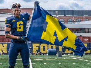 Collins Acheampong holds the UMich football flag