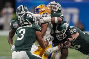 Michigan State's defense ganging up on a tackler during their Peach Bowl victory against Pittsburgh