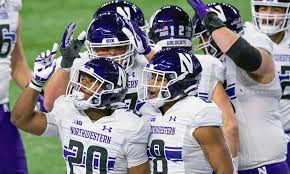 A group of Northwestern players celebrate a touchdown in 2021.