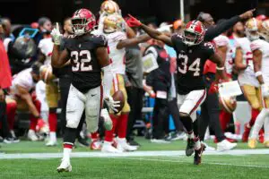 Falcons Jaylinn Hawkins (32) and Darren Hall (34) celebrate fumble recovery touchdown by Hawkins wearing throwback uniforms/The Falcoholic