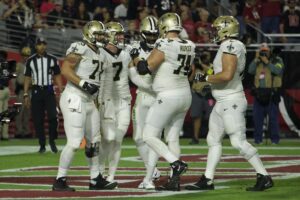Taysom Hill celebrates with his team after scoring a touchdown against the Arizona Cardinals. 
