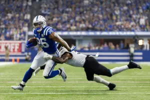 Sep 10, 2023; Indianapolis, Indiana, USA; Indianapolis Colts running back Evan Hull (26) runs the ball while Jacksonville Jaguars safety Andre Cisco (5) defends in the second half at Lucas Oil Stadium. Mandatory Credit: Trevor Ruszkowski-USA TODAY Sports