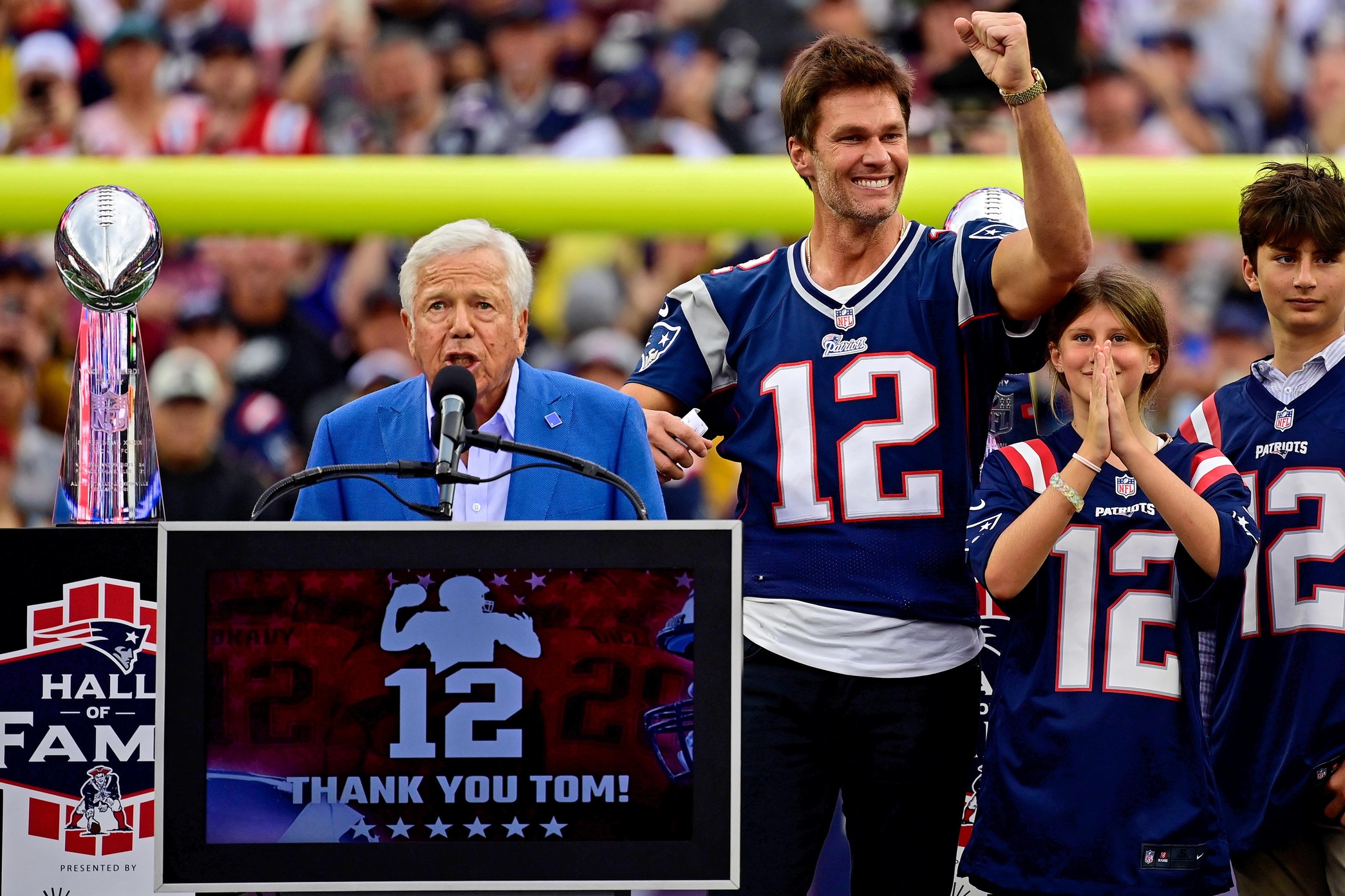 Sep 10, 2023; Foxborough, Massachusetts, USA; New England Patriots former quarterback Tom Brady gestures as New England Patriots owner Robert Kraft speaks during a halftime ceremony in his honor during the game between the Philadelphia Eagles and New England Patriots at Gillette Stadium. Mandatory Credit: Eric Canha-USA TODAY Sports