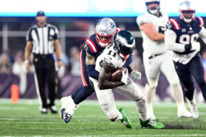 Sep 10, 2023; Foxborough, Massachusetts, USA; Philadelphia Eagles wide receiver A.J. Brown (11) is tackled by New England Patriots cornerback Christian Gonzalez (6) during the second half at Gillette Stadium. Mandatory Credit: Brian Fluharty-USA TODAY Sports