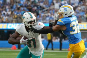 Sep 10, 2023; Inglewood, California, USA; Miami Dolphins running back Raheem Mostert (31) carries the ball against Los Angeles Chargers safety Alohi Gilman (32) in the second half at SoFi Stadium. Mandatory Credit: Kirby Lee-USA TODAY Sports