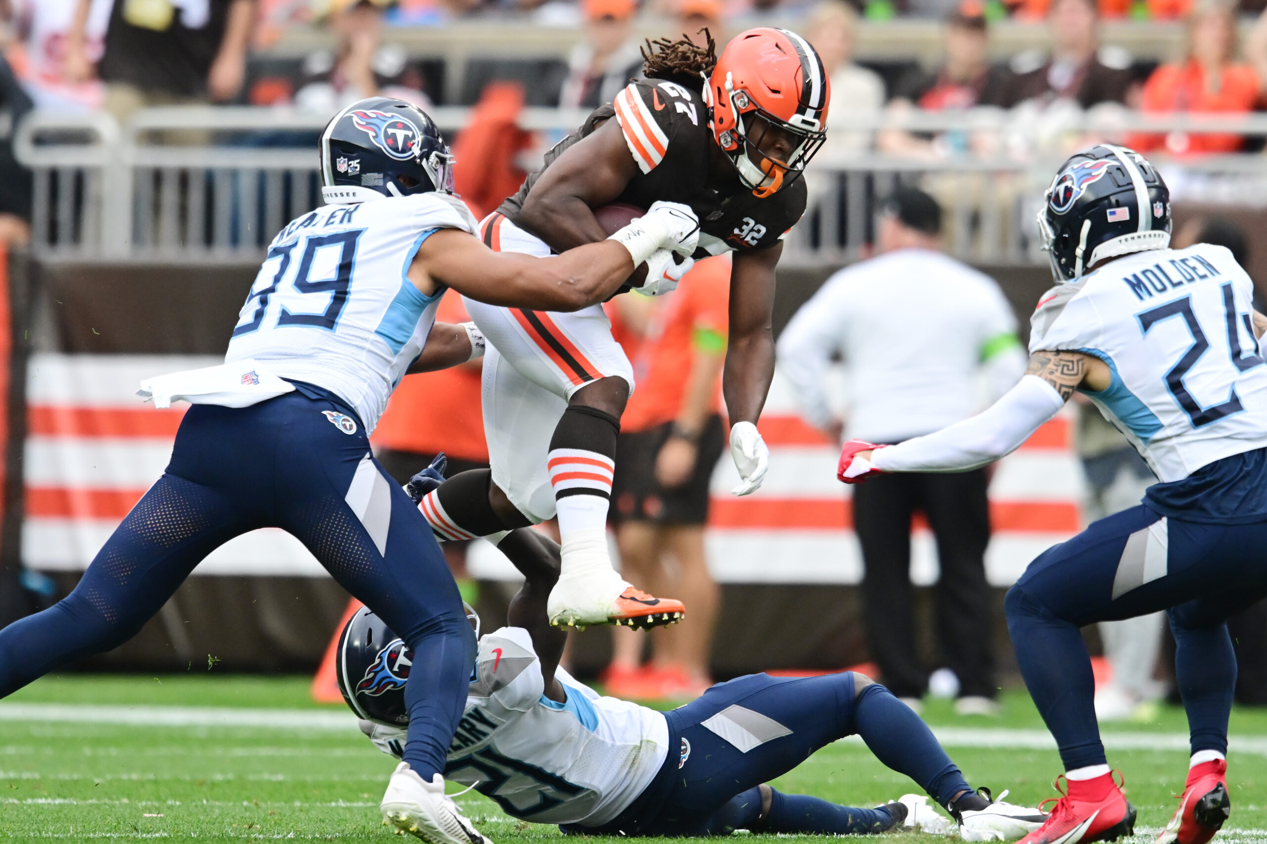Sep 24, 2023; Cleveland, Ohio, USA; Cleveland Browns running back Kareem Hunt (27) jumps over Tennessee Titans cornerback Roger McCreary (21) during the second half at Cleveland Browns Stadium. Mandatory Credit: Ken Blaze-USA TODAY Sports