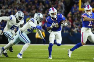 Dec 17, 2023; Orchard Park, New York, USA; Buffalo Bills running back James Cook (4) runs the ball pressured by Dallas Cowboys linebacker Rashaan Evans (32) in the first half at Highmark Stadium. Mandatory Credit: Gregory Fisher-USA TODAY Sports