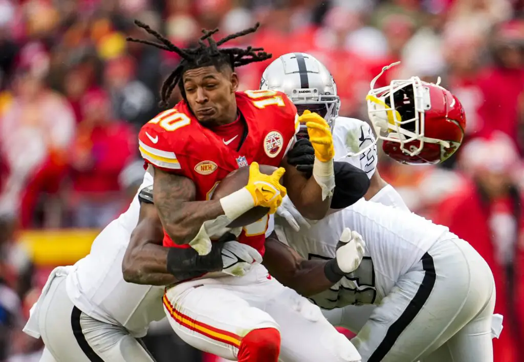 Dec 25, 2023; Kansas City, Missouri, USA; Kansas City Chiefs running back Isiah Pacheco (10) loses his helmet as he is tackled by Las Vegas Raiders defensive end Tyree Wilson (9) and defensive end Malcolm Koonce (51) and cornerback Nate Hobbs (39) during the second half at GEHA Field at Arrowhead Stadium. Mandatory Credit: Jay Biggerstaff-USA TODAY Sports (Cincinnati Bengals)