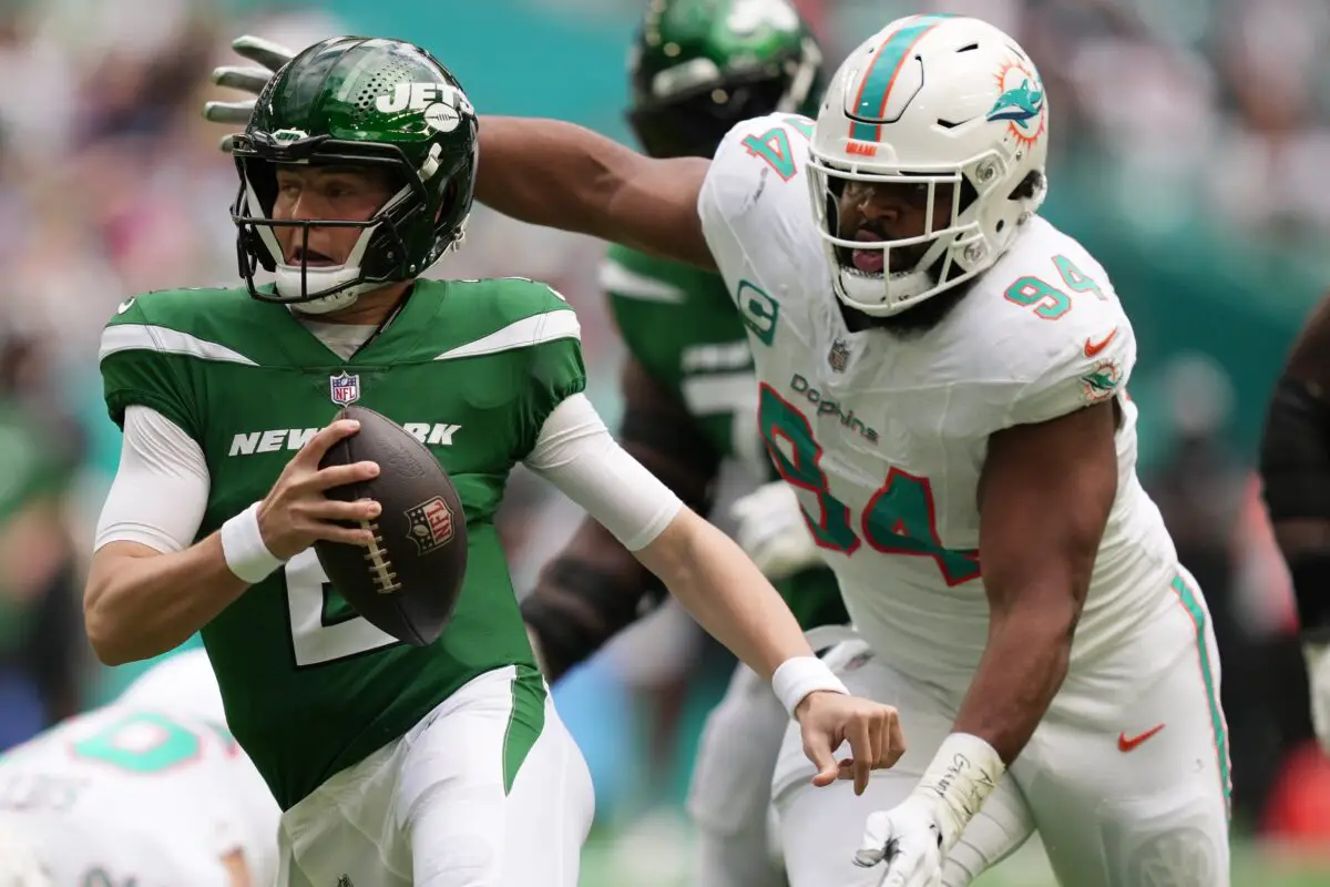 New York Jets quarterback Zach Wilson tries to elude the pressure of Miami Dolphins defensive tackle Christian Wilkins during the first half at Hard Rock Stadium in Miami Gardens, Dec. 17, 2023. © Jim Rassol / USA TODAY NETWORK