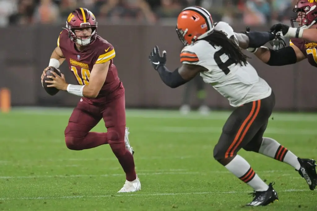 Aug 11, 2023; Cleveland, Ohio, USA; Washington Commanders quarterback Sam Howell (14) scrambles from Cleveland Browns defensive end Lonnie Phelps (63) during the first half at Cleveland Browns Stadium. Mandatory Credit: Ken Blaze-USA TODAY Sports