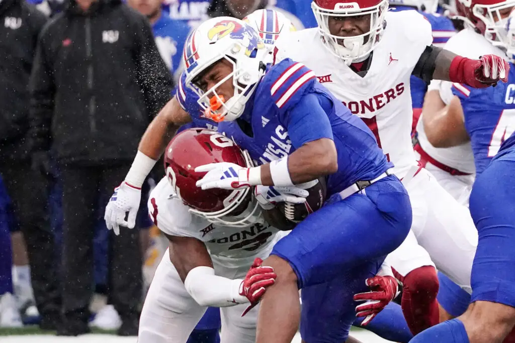 Oct 28, 2023; Lawrence, Kansas, USA; Kansas Jayhawks wide receiver Trevor Wilson (7) runs the ball as Oklahoma Sooners defensive back Robert Spears-Jennings (3) makes the tackle during the first half at David Booth Kansas Memorial Stadium. Mandatory Credit: Denny Medley-USA TODAY Sports