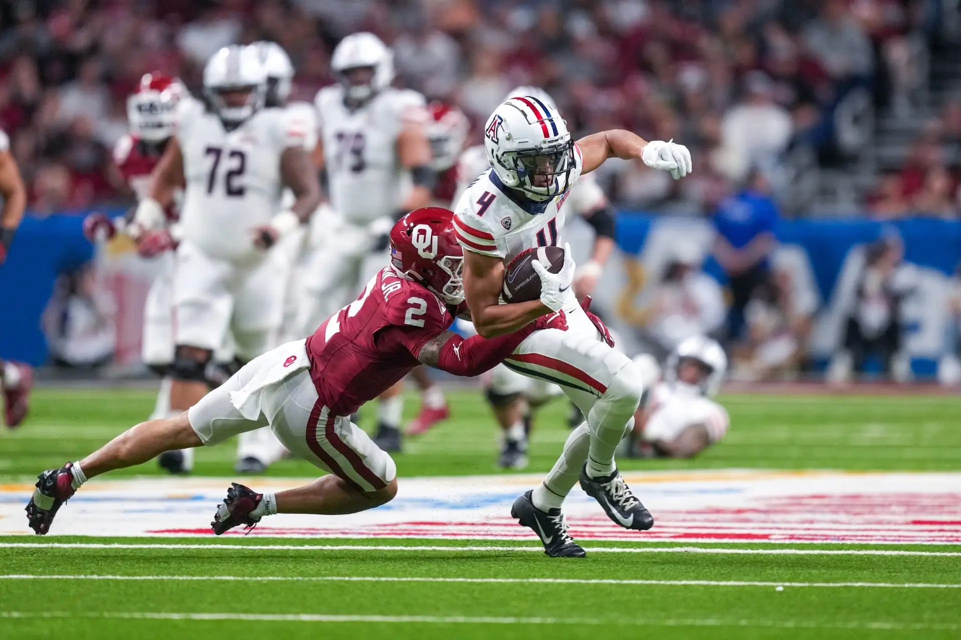 Dec 28, 2023; San Antonio, TX, USA; Oklahoma Sooners defensive back Billy Bowman Jr. (2) brings down Arizona Wildcats wide receiver Tetairoa McMillan (4) in the first half at Alamodome. Mandatory Credit: Daniel Dunn-USA TODAY Sports (Los Angeles Rams)