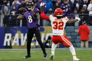 Jan 28, 2024; Baltimore, Maryland, USA; Baltimore Ravens quarterback Lamar Jackson (8) passes the ball as Kansas City Chiefs linebacker Nick Bolton (32) defends in the AFC Championship football game at M&T Bank Stadium. Mandatory Credit: Geoff Burke-USA TODAY Sports