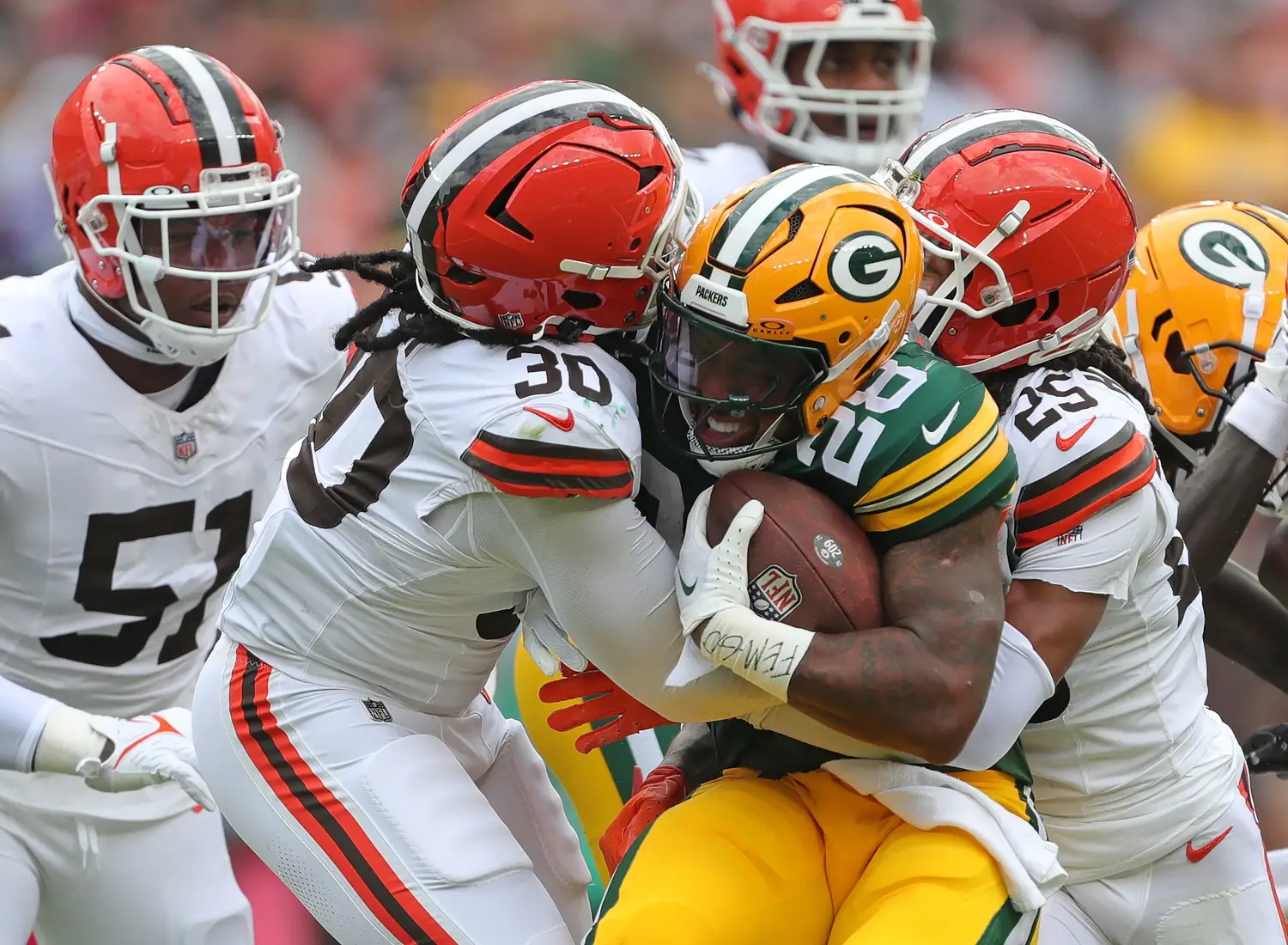 Green Bay Packers running back AJ Dillon (28) is sandwiched between Cleveland Browns linebacker Devin Bush (30) and Cleveland Browns cornerback Kahlef Hailassie (25) during the first half of an NFL preseason football game at Cleveland Browns Stadium, Saturday, Aug. 10, 2024, in Cleveland, Ohio. © Jeff Lange / USA TODAY NETWORK