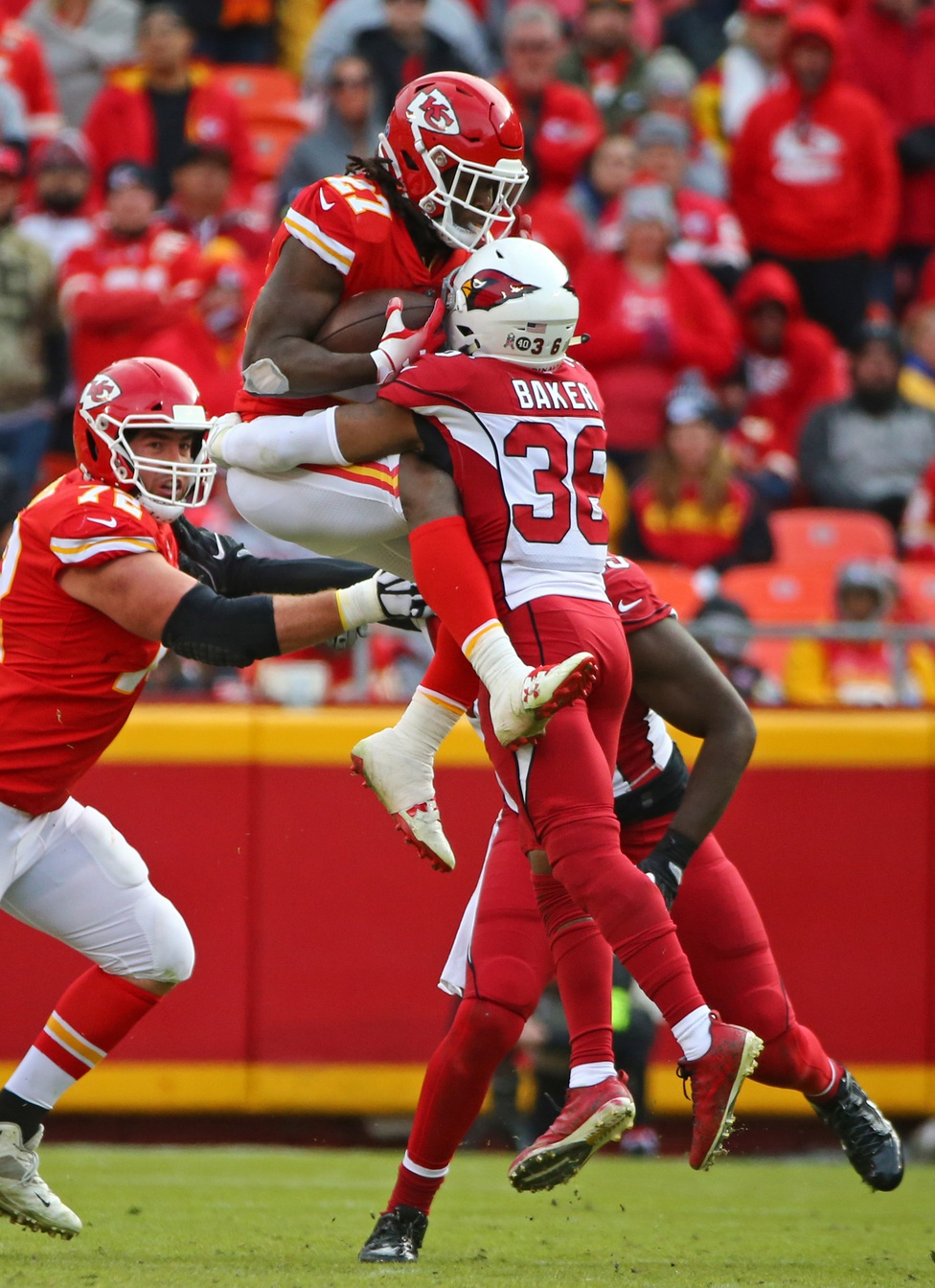 Nov 11, 2018; Kansas City, MO, USA; Kansas City Chiefs running back Kareem Hunt (27) jumps into? Arizona Cardinals safety Budda Baker (36) in the second half at Arrowhead Stadium. Mandatory Credit: Jay Biggerstaff-Imagn Images