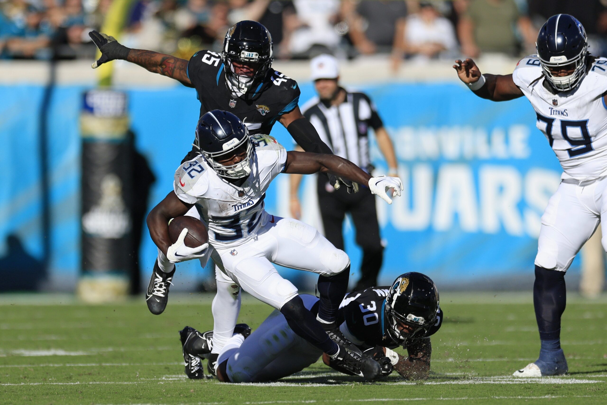 Tennessee Titans running back Tyjae Spears (32) is tackled by Jacksonville Jaguars cornerback Montaric Brown (30) as linebacker K'Lavon Chaisson (45) pressures during the third quarter an NFL football matchup Sunday, Nov. 19, 2023 at EverBank Stadium in Jacksonville, Fla. The Jacksonville Jaguars defeated the Tennessee Titans 34-14. [Corey Perrine/Florida Times-Union] (Raiders)