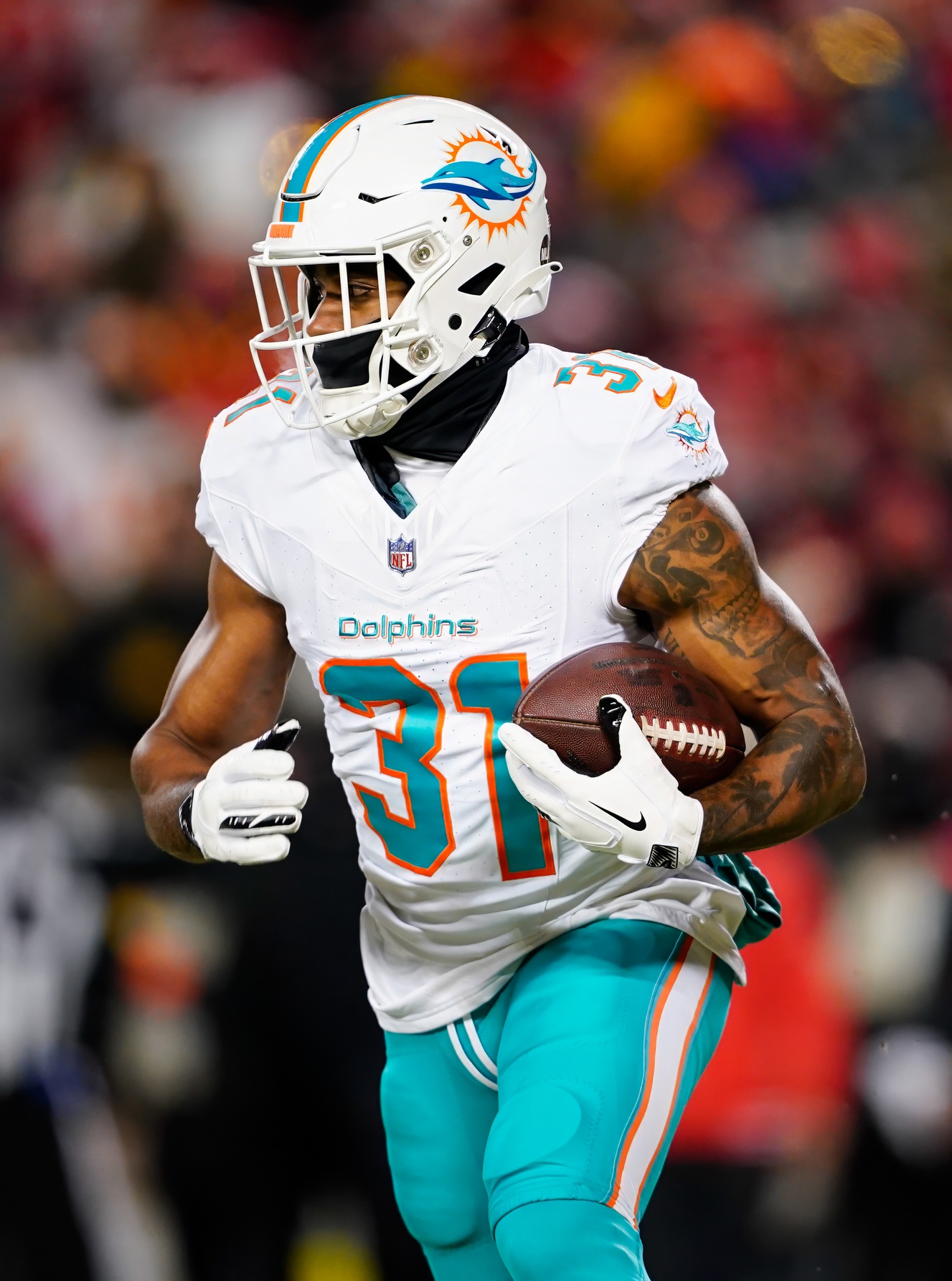 Jan 13, 2024; Kansas City, Missouri, USA; Miami Dolphins running back Raheem Mostert (31) runs the ball during the first half of a 2024 AFC wild card game against the Kansas City Chiefs at GEHA Field at Arrowhead Stadium. Mandatory Credit: Jay Biggerstaff-Imagn Images