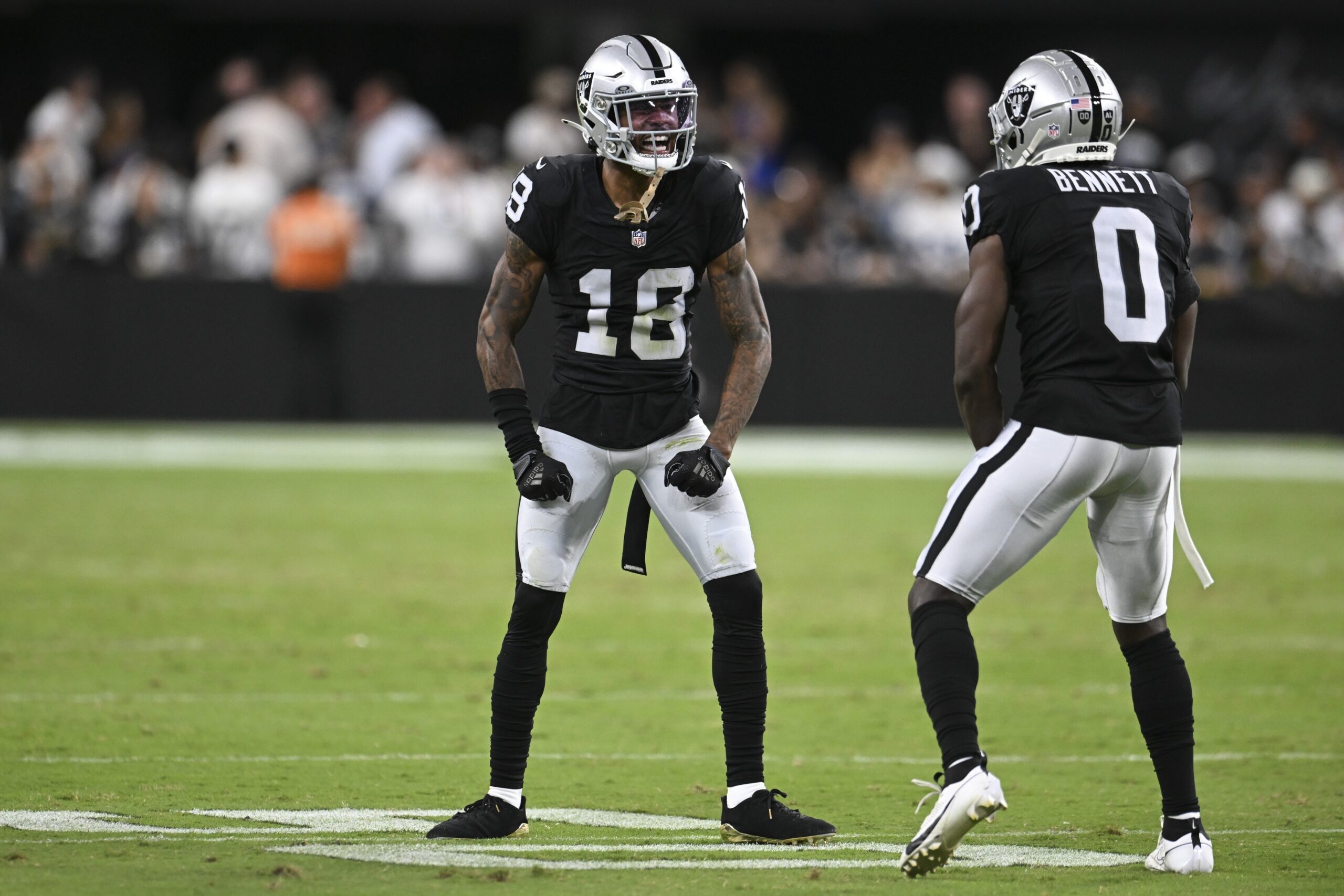 Aug 17, 2024; Paradise, Nevada, USA; Las Vegas Raiders cornerback Jack Jones (18) and cornerback Jakorian Bennett (0) celebrate a play against the Dallas Cowboys in the first quarter at Allegiant Stadium. Mandatory Credit: Candice Ward-Imagn Images