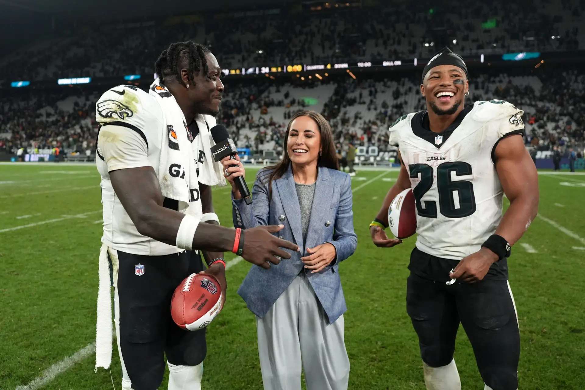 Sep 6, 2024; Sao Paulo, Brazil; Peacock sideline reporter Kaylee Hartung (center) interviews Philadelphia Eagles wide receiver A.J. Brown (11) and running back Saquon Barkley (26) after the 2024 NFL Sao Paolo Game at Neo Quimica Arena. Mandatory Credit: Kirby Lee-Imagn Images