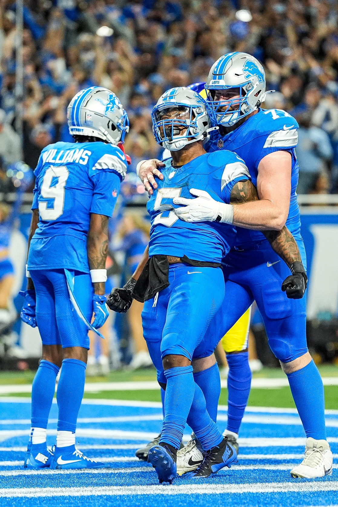 Detroit Lions running back David Montgomery (5) celebrates scoring a touchdown against Los Angeles Rams with center Frank Ragnow (77) during overtime at Ford Field in Detroit on Sunday, September 8, 2024. © Junfu Han / USA TODAY NETWORK