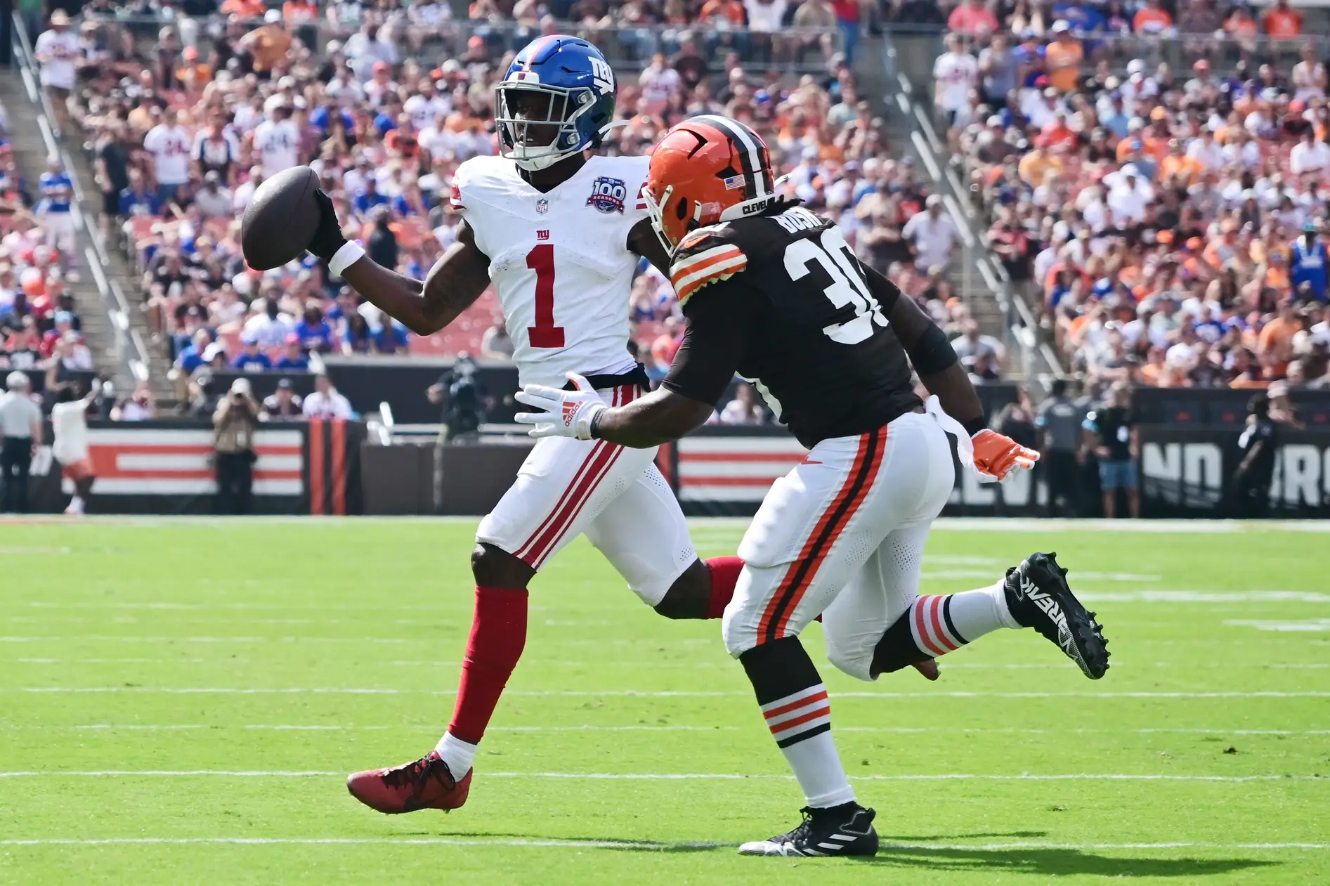 Sep 22, 2024; Cleveland, Ohio, USA; New York Giants wide receiver Malik Nabers (1) looks to make a pass as Cleveland Browns linebacker Devin Bush (30) defends during the first half at Huntington Bank Field. Mandatory Credit: Ken Blaze-Imagn Images