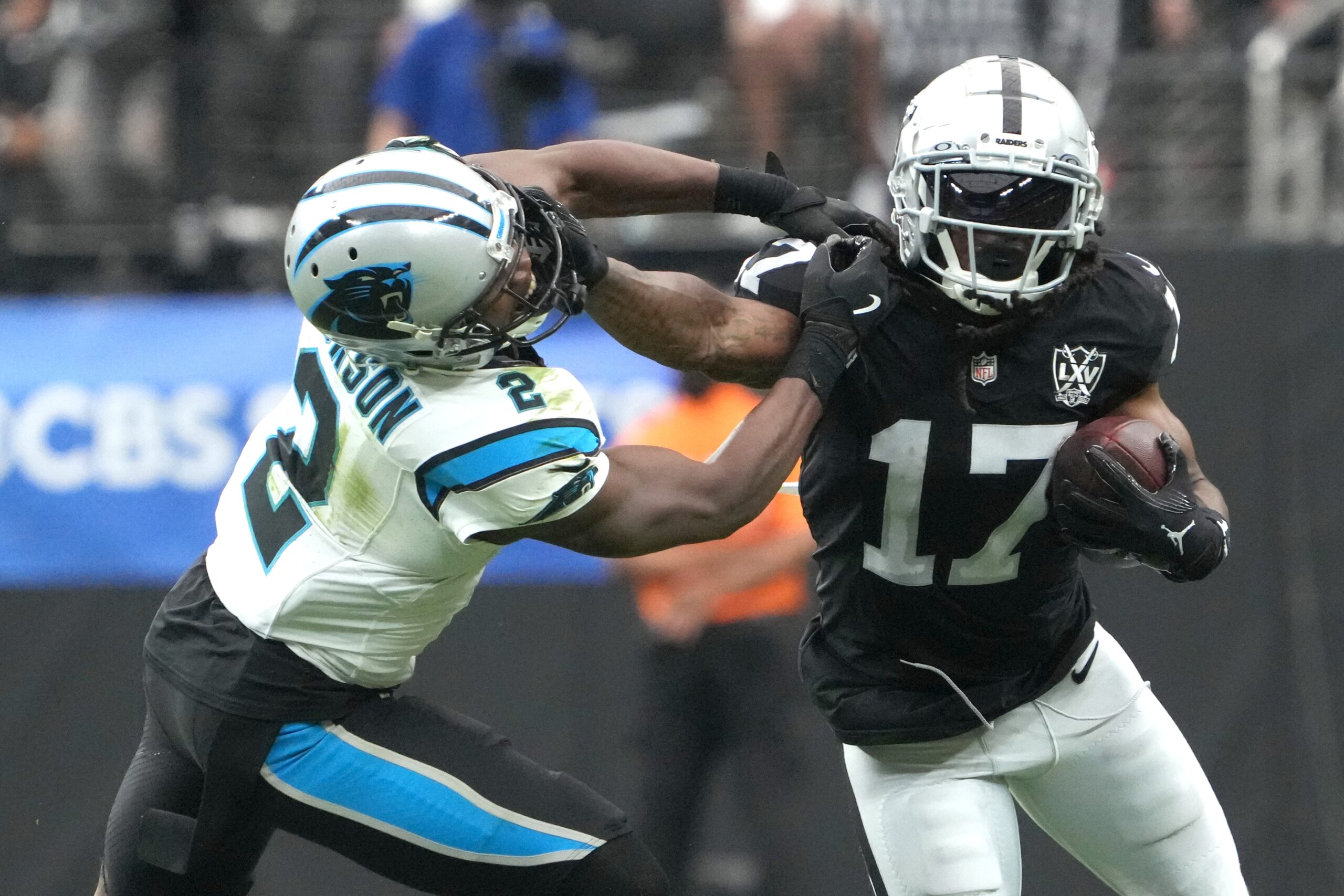 Sep 22, 2024; Paradise, Nevada, USA; Las Vegas Raiders wide receiver Davante Adams (17) carries the ball against Carolina Panthers cornerback Michael Jackson (2) in the first half at Allegiant Stadium. Mandatory Credit: Kirby Lee-Imagn Images