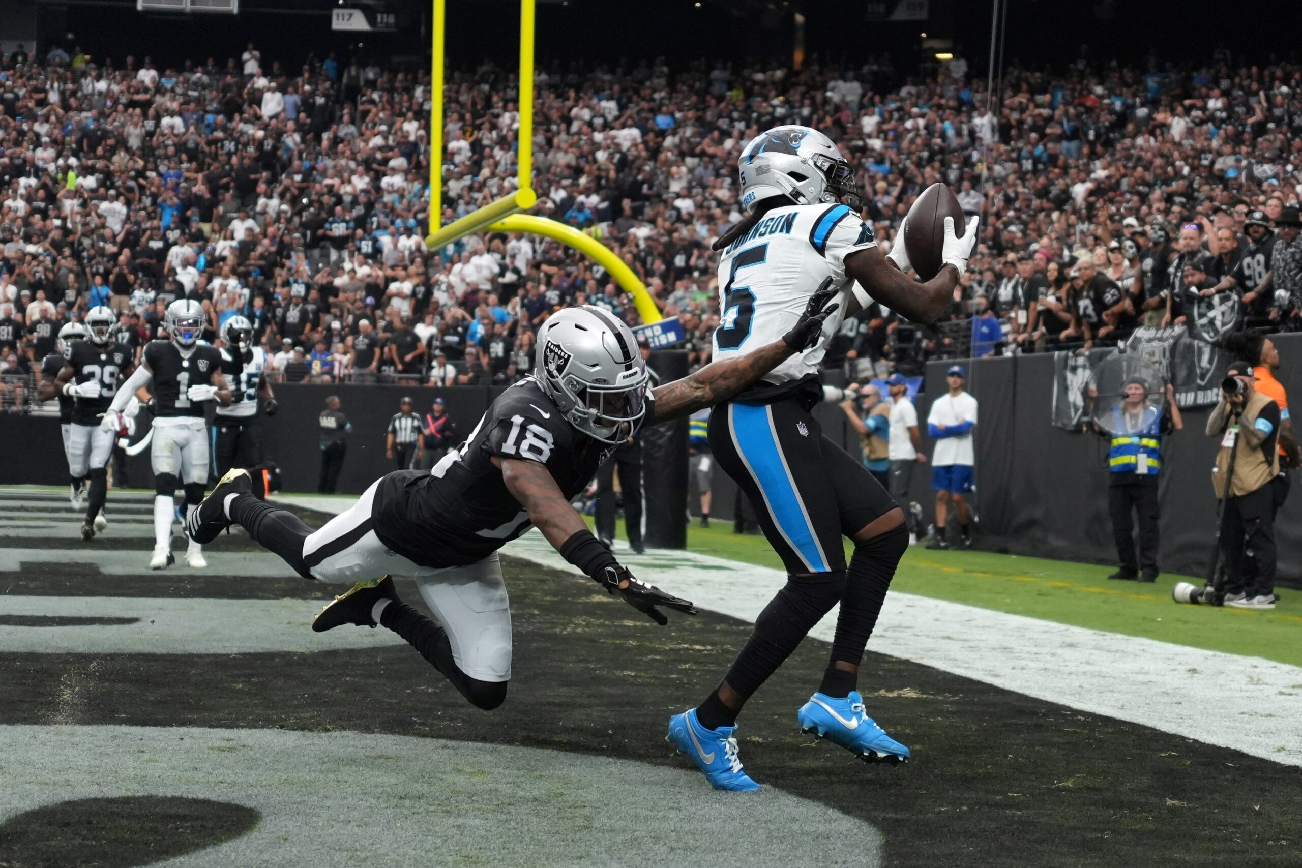 Sep 22, 2024; Paradise, Nevada, USA; Carolina Panthers wide receiver Diontae Johnson (5) catches a 5-yard touchdown pass against Las Vegas Raiders cornerback Jack Jones (18) in the first half at Allegiant Stadium. Mandatory Credit: Kirby Lee-Imagn Images