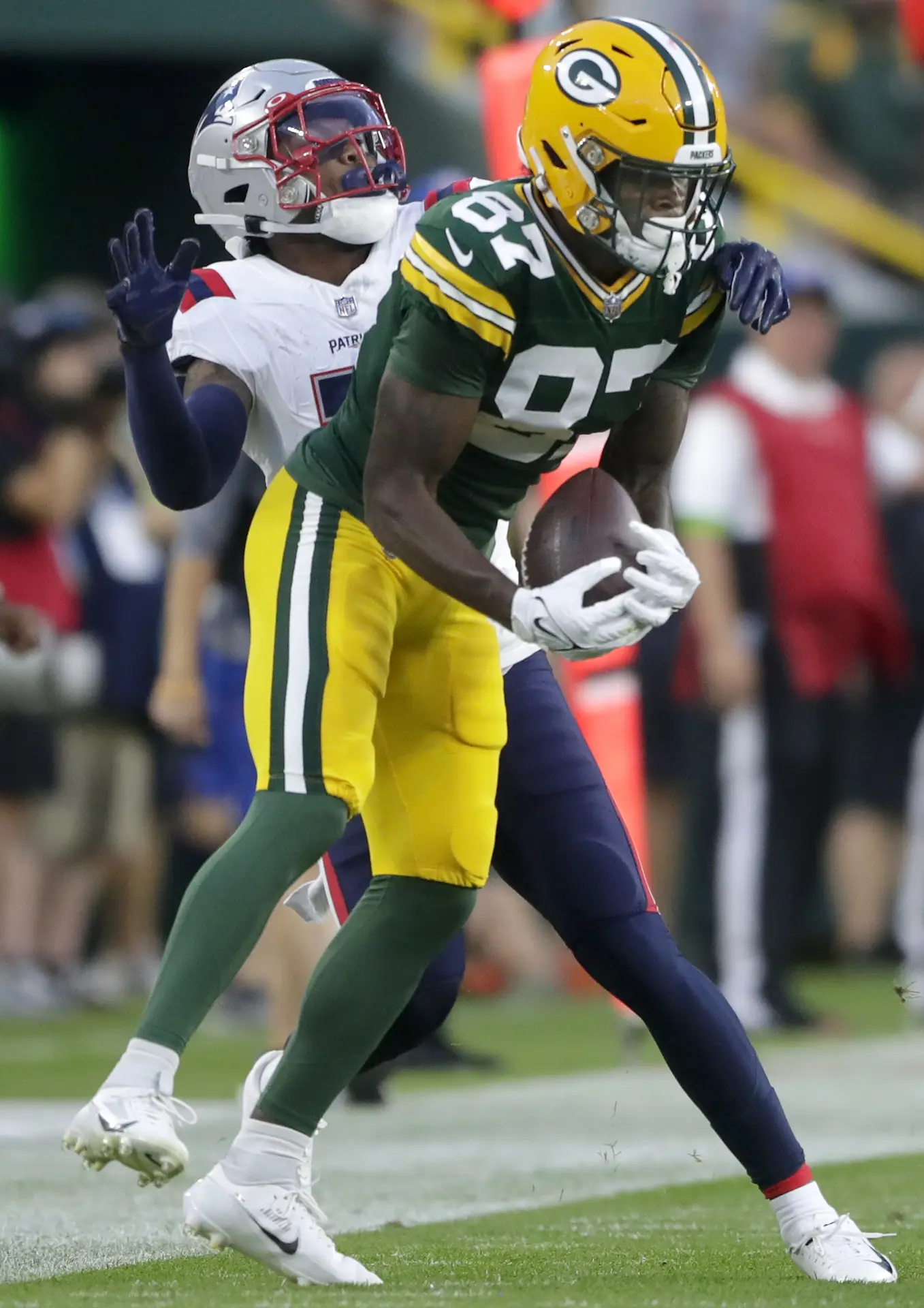 Aug 19, 2023; Green Bay, WI, USA; Green Bay Packers wide receiver Romeo Doubs (87) makes a sideline reception, in the first quarter, in front of New England Patriots cornerback Isaiah Bolden (7) during their preseason football game at Lambeau Field. Mandatory Credit: William Glasheen-Imagn Images