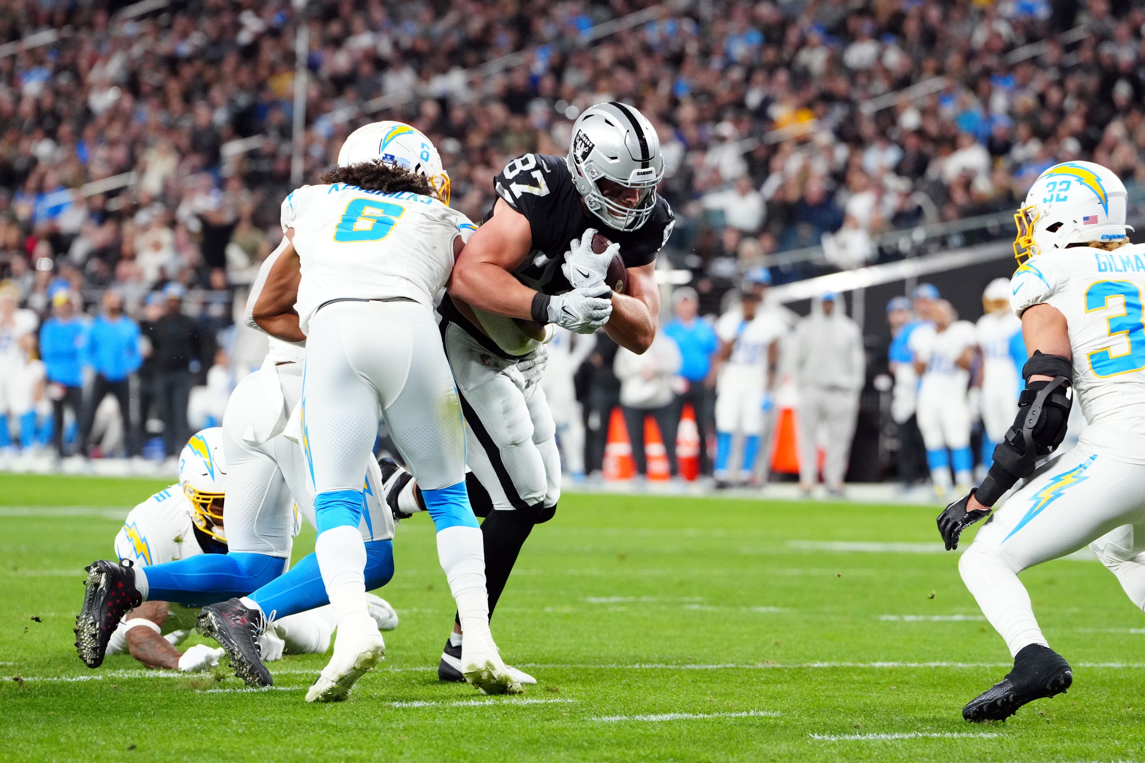 Dec 14, 2023; Paradise, Nevada, USA; Las Vegas Raiders tight end Michael Mayer (87) runs against Los Angeles Chargers linebacker Eric Kendricks (6) in the first quarter at Allegiant Stadium. Mandatory Credit: Stephen R. Sylvanie-Imagn Images