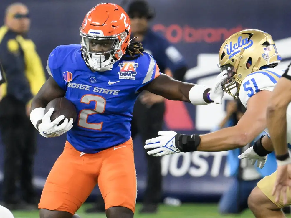 Dec 16, 2023; Inglewood, CA, USA; Boise State Broncos running back Ashton Jeanty (2) stiff arms UCLA Bruins defensive lineman Jake Heimlicher (51) in the first quarter during the Starco Brands LA Bowl at SoFi Stadium. Mandatory Credit: Robert Hanashiro-Imagn Images (Bears)