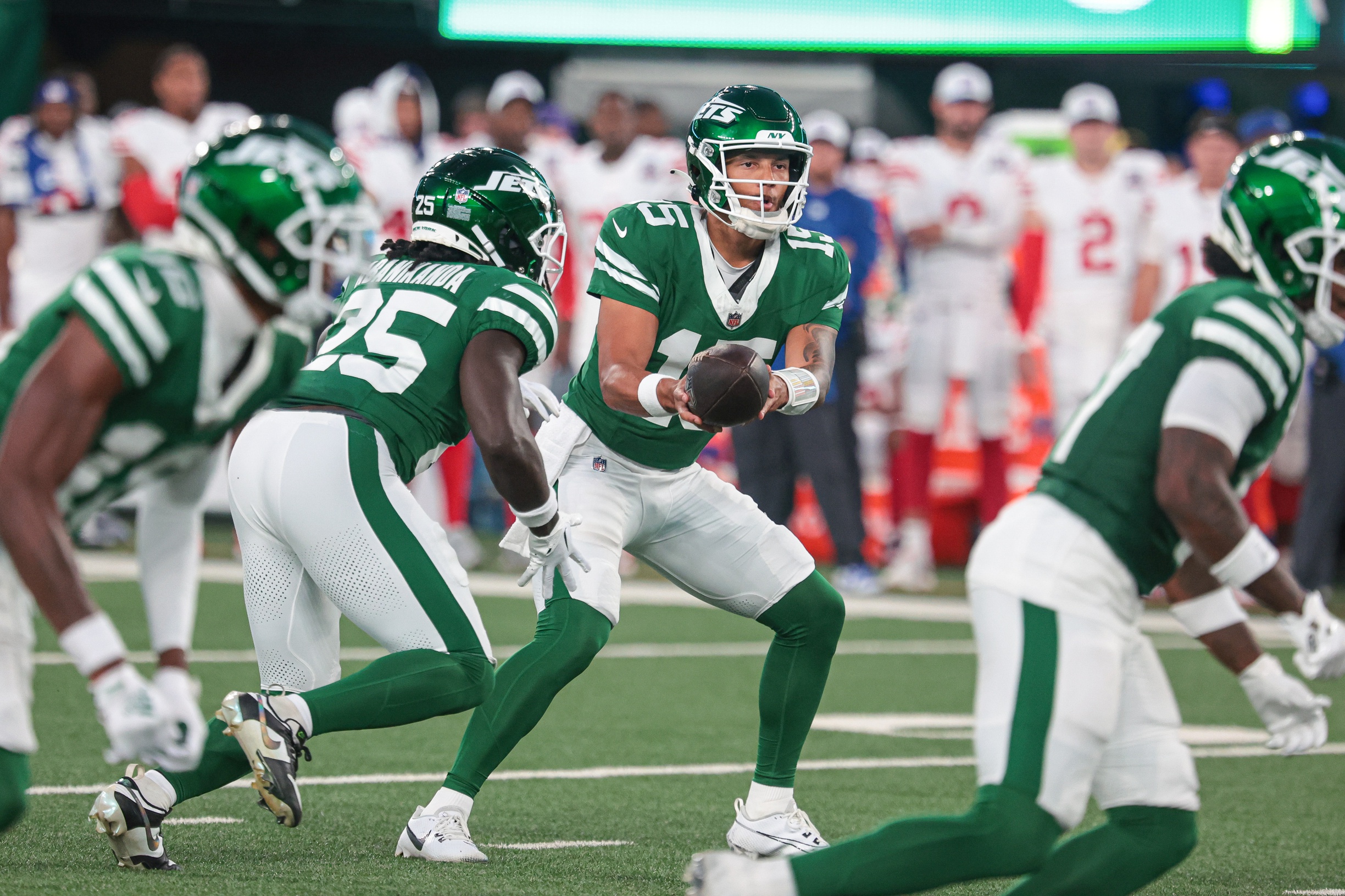 Aug 24, 2024; East Rutherford, New Jersey, USA; New York Jets quarterback Adrian Martinez (15) hands off to running back Israel Abanikanda (25) during the first quarter against the New York Giants at MetLife Stadium. Mandatory Credit: Vincent Carchietta-Imagn Images