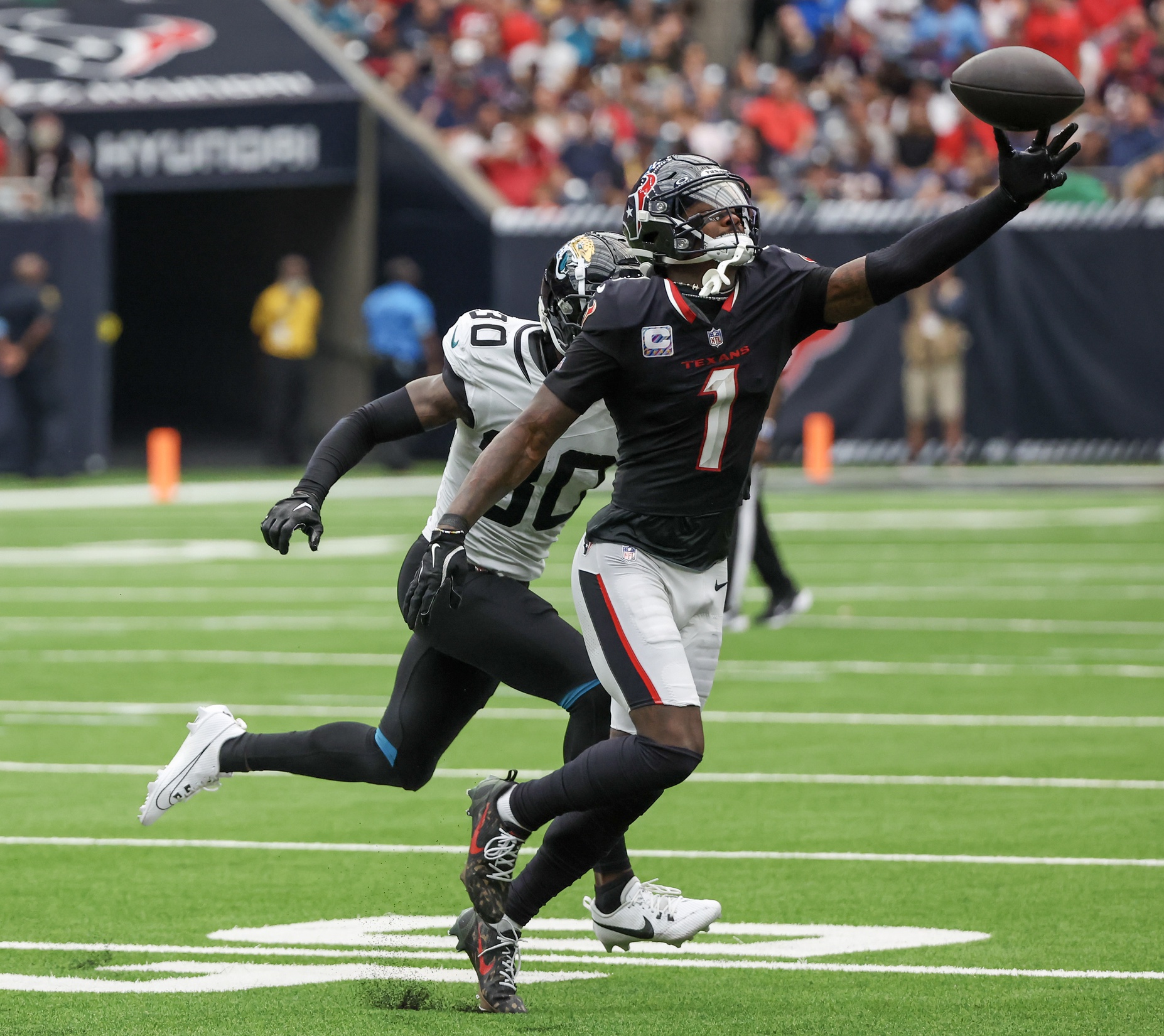 Sep 29, 2024; Houston, Texas, USA; Houston Texans wide receiver Stefon Diggs (1) drops the pass while being covered by Jacksonville Jaguars cornerback Montaric Brown (30) in the second half at NRG Stadium. Mandatory Credit: Thomas Shea-Imagn Images