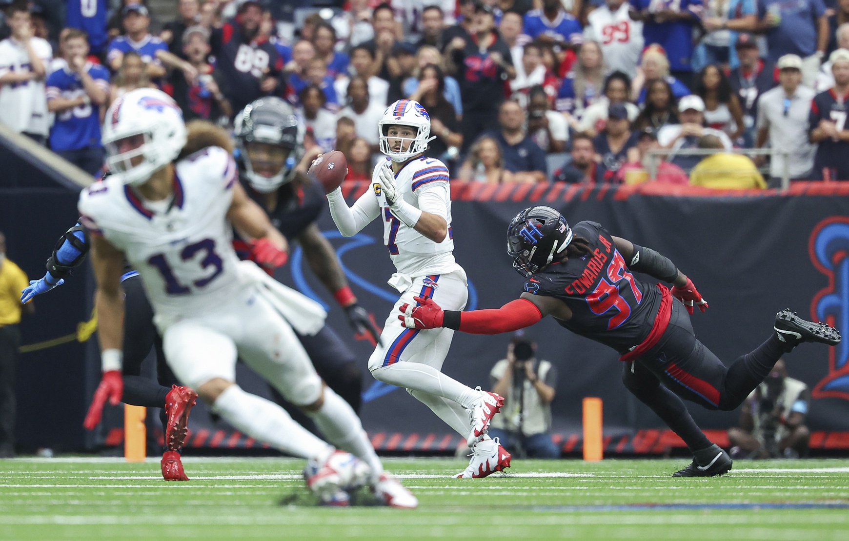 Oct 6, 2024; Houston, Texas, USA; Buffalo Bills quarterback Josh Allen (17) scrambles with the ball as Houston Texans defensive tackle Mario Edwards Jr. (97) applies defensive pressure during the fourth quarter at NRG Stadium. Mandatory Credit: Troy Taormina-Imagn Images