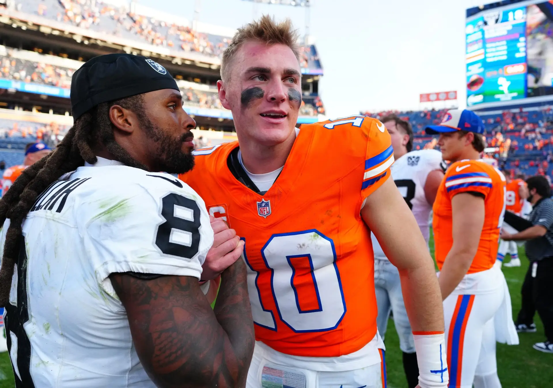 Oct 6, 2024; Denver, Colorado, USA; Las Vegas Raiders running back Ameer Abdullah (8) and Denver Broncos quarterback Bo Nix (10) following the game at Empower Field at Mile High. Mandatory Credit: Ron Chenoy-Imagn Images