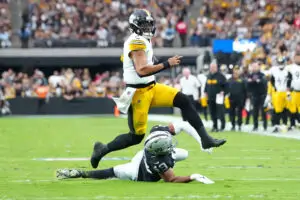 Oct 13, 2024; Paradise, Nevada, USA; Pittsburgh Steelers quarterback Justin Fields (2) evades the tackle attempt of Las Vegas Raiders defensive end Charles Snowden (49) during the second quarter at Allegiant Stadium. Mandatory Credit: Stephen R. Sylvanie-Imagn Images