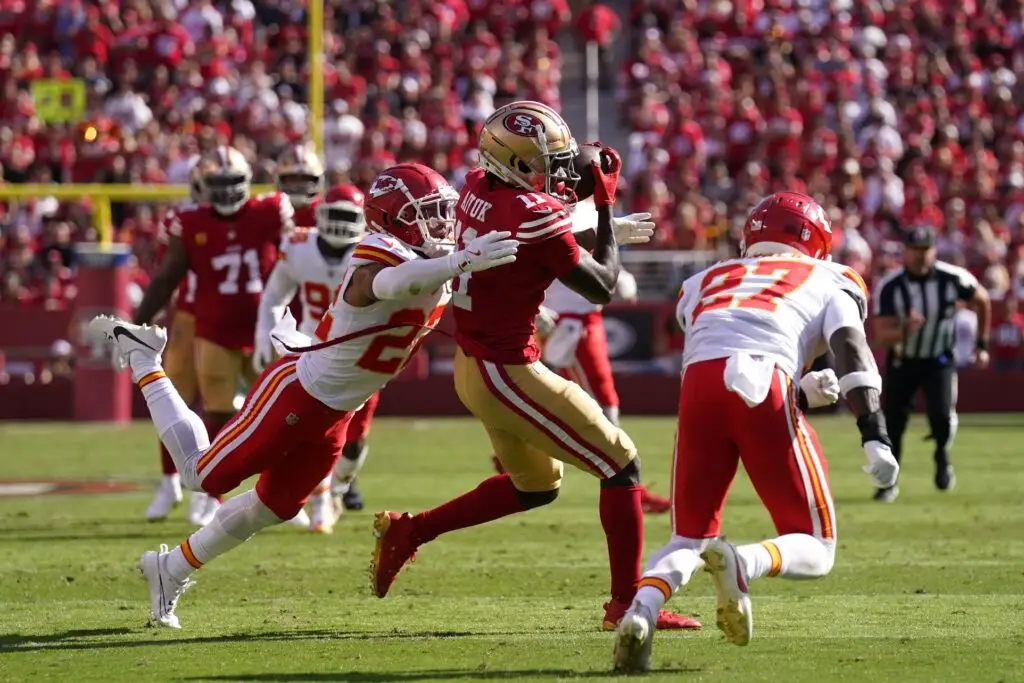 Oct 20, 2024; Santa Clara, California, USA; San Francisco 49ers wide receiver Brandon Aiyuk (11) catches a pass between Kansas City Chiefs cornerback Trent McDuffie (22) and safety Chamarri Conner (27) in the second quarter at Levi's Stadium. Mandatory Credit: Cary Edmondson-Imagn Images