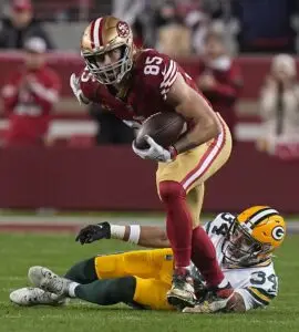 Jan 20, 2024; Santa Clara, CA, USA; San Francisco 49ers tight end George Kittle (85) picks up 32 yard on a reception after a missed tackle by Green Bay Packers safety Jonathan Owens during the third quarter at Levi's Stadium. Mandatory Credit: Mark Hoffman-Imagn Images