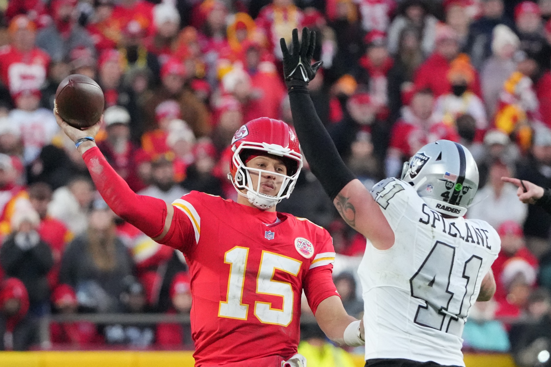 Nov 29, 2024; Kansas City, Missouri, USA; Kansas City Chiefs quarterback Patrick Mahomes (15) throws a pass as Las Vegas Raiders linebacker Robert Spillane (41) defends during the second half at GEHA Field at Arrowhead Stadium. Mandatory Credit: Denny Medley-Imagn Images