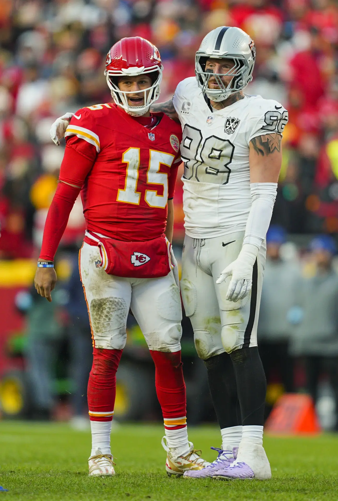 Nov 29, 2024; Kansas City, Missouri, USA; Kansas City Chiefs quarterback Patrick Mahomes (15) and Las Vegas Raiders defensive end Maxx Crosby (98) embrace during the second half at GEHA Field at Arrowhead Stadium. Mandatory Credit: Jay Biggerstaff-Imagn Images