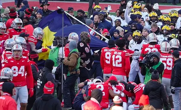 Ohio State football defensive end Jack Sawyer (33) grabs the flag that Michigan players tried to plant on the Block O in the Ohio Stadium field after the NCAA football game against the Michigan Wolverines Saturday, November 30, 2024 in Ohio Stadium.