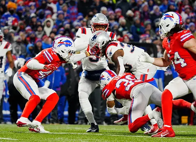 New England Patriots Rhamondre Stevenson escapes Buffalo Bills Christian Benford and Cam Lewis' tackle and ran into the end zone for a touchdown during first half action at Highmark Stadium where the Buffalo Bills hosted the New England Patriots in Orchard Park on Dec. 22, 2024.Tina MacIntyre-Yee/Democrat And Chronicle