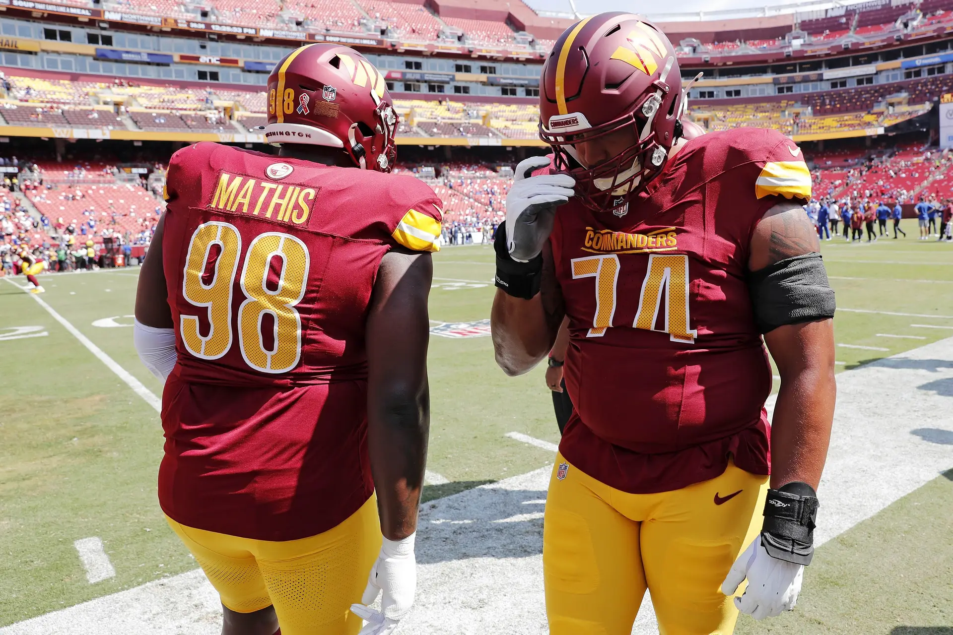 Sep 15, 2024; Landover, Maryland, USA; Washington Commanders defensive tackle Phidarian Mathis (98) and offensive tackle Brandon Coleman (74) greet each other before playing against the New York Giants at Commanders Field. Mandatory Credit: Peter Casey-Imagn Images Jets