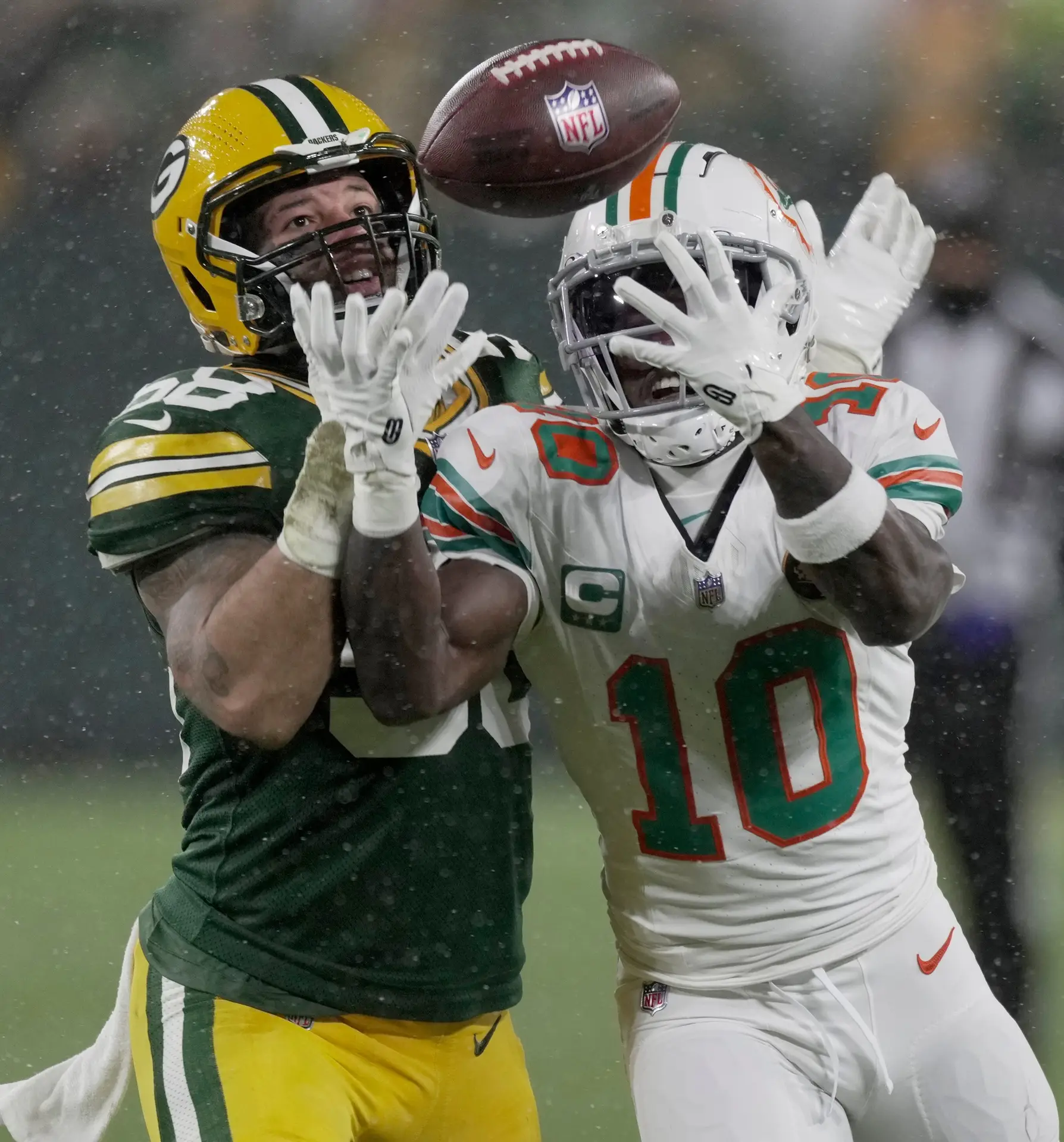 Miami Dolphins wide receiver Tyreek Hill (10) catches a pass for two yards while being covered by Green Bay Packers linebacker Isaiah McDuffie (58) during the second quarter of their game Thursday, November 28, 2024 at Lambeau Field in Green Bay, Wisconsin.