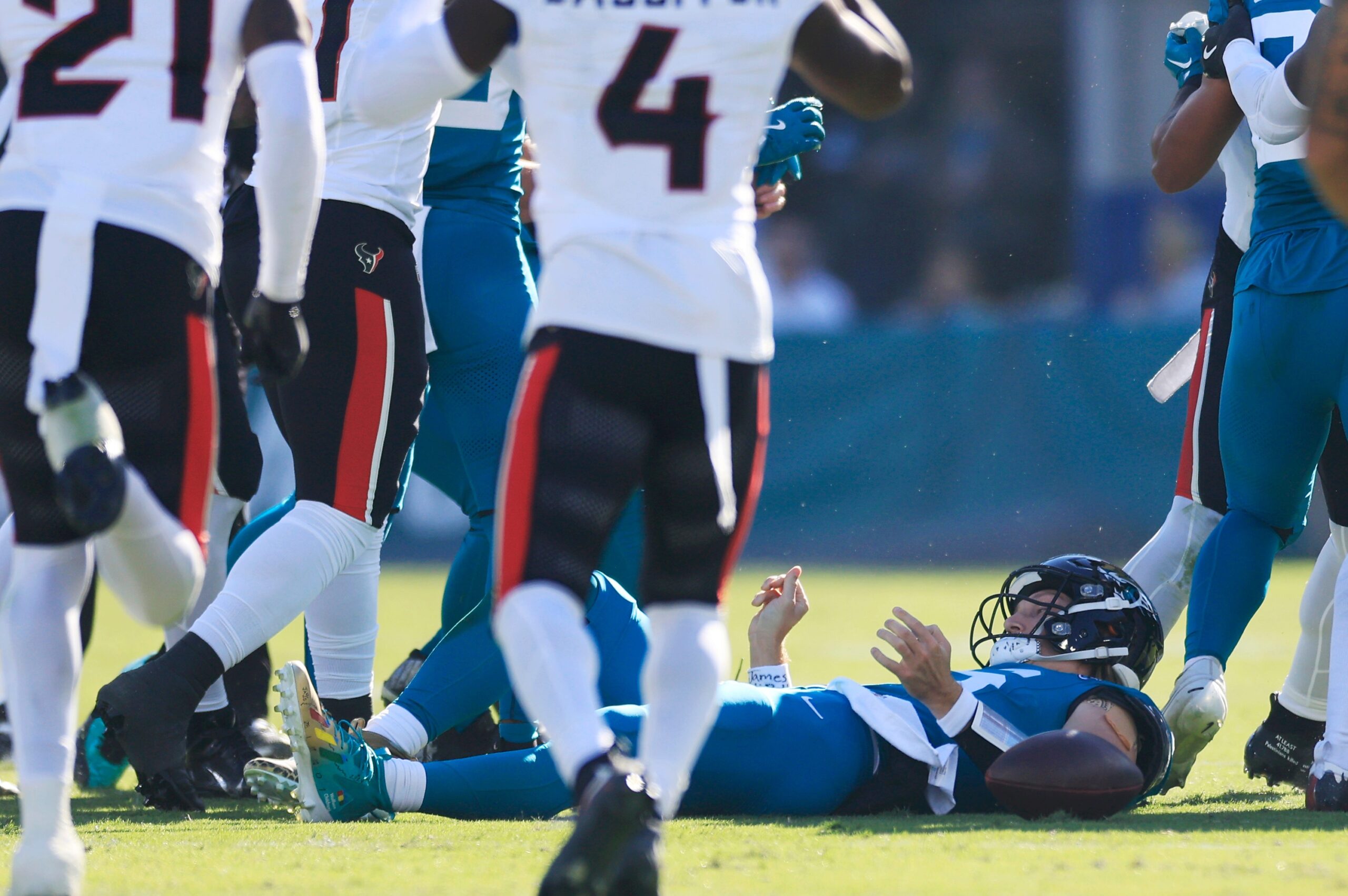 Jacksonville Jaguars quarterback Trevor Lawrence (16) is shaken after a hit from Houston Texans linebacker Azeez Al-Shaair (0) during the second quarter of an NFL football matchup Sunday, Dec. 1, 2024 at EverBank Stadium in Jacksonville, Fla. [Corey Perrine/Florida Times-Union]