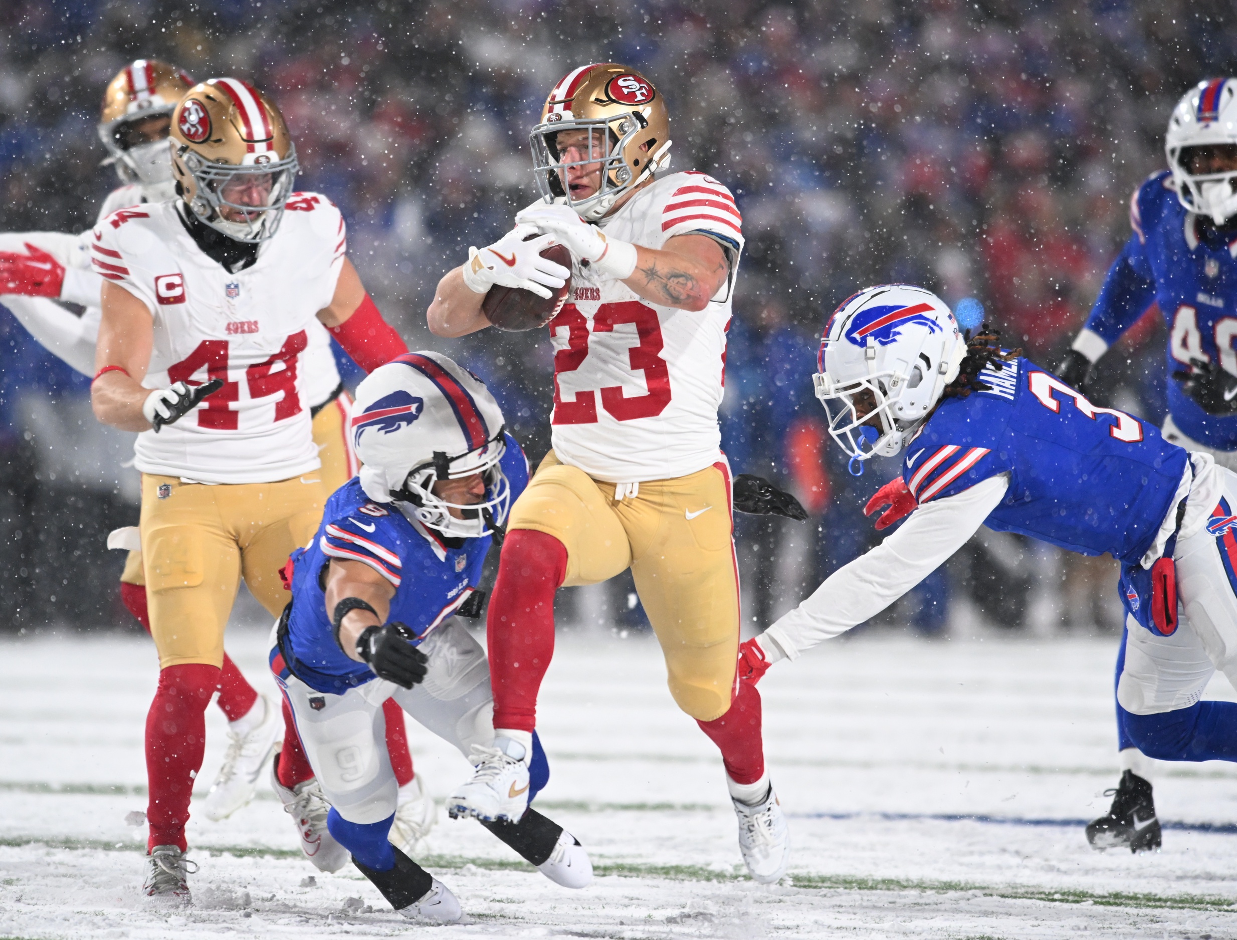 Dec 1, 2024; Orchard Park, New York, USA; San Francisco 49ers running back Christian McCaffrey (23) is tackled by Buffalo Bills safety Taylor Rapp (9) and safety Damar Hamlin (3) in the second quarter at Highmark Stadium. Mandatory Credit: Mark Konezny-Imagn Images